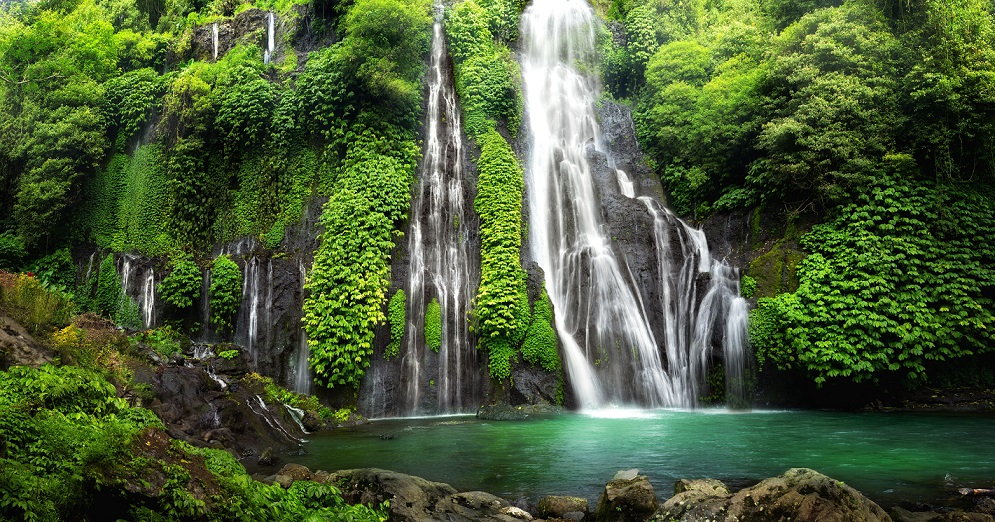 Jungle waterfall cascade in tropical rainforest with rock and tu