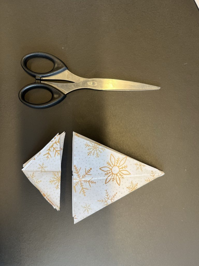 scissors next to two triangle papers